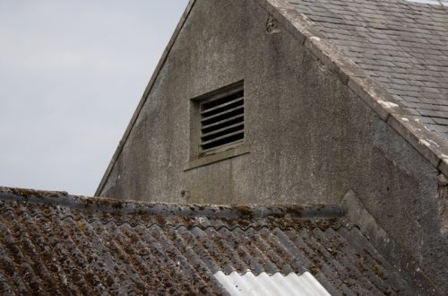 an old building with a small window on the roof