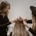 a woman getting her hair styled by another woman