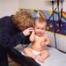a woman is talking on a phone to a baby